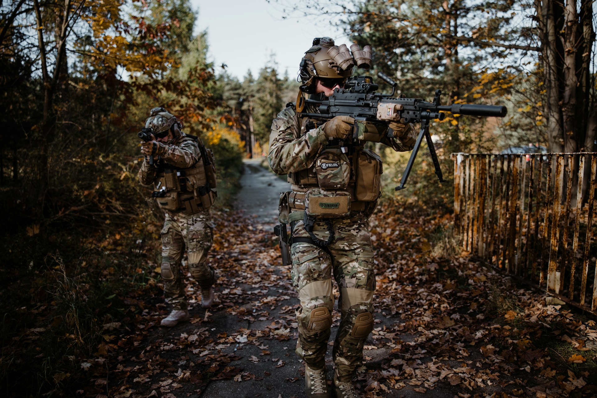 a couple of soldiers walking down a dirt road